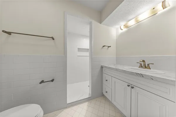 a bathroom with a granite countertop sink toilet and shower