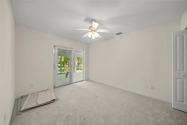 an empty room with windows and fan