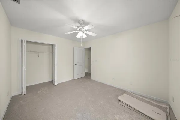 an empty room with a ceiling fan and a window