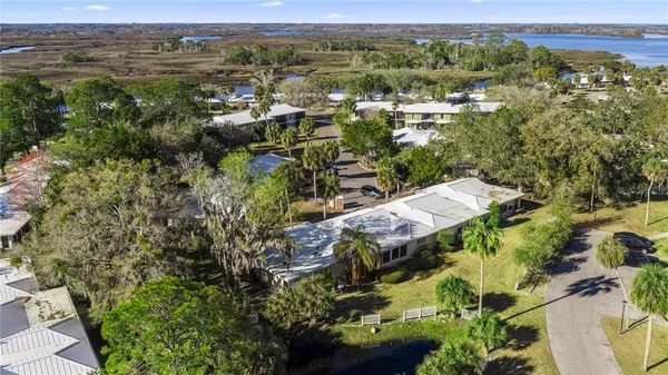 an aerial view of a residential houses with outdoor space and trees