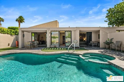 a view of a house with swimming pool and porch with a table and chairs