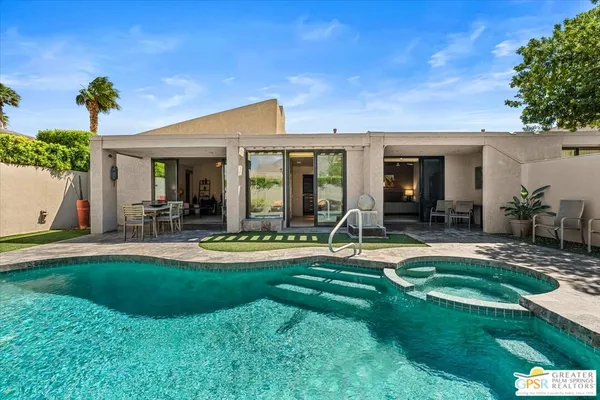 a view of a house with swimming pool and porch with a table and chairs