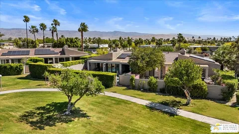 a view of a house with a big yard and potted plants