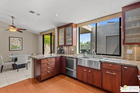 a large kitchen with kitchen island granite countertop wooden cabinets and a granite counter tops