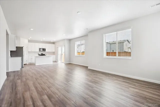 a view of a kitchen with wooden floor and windows