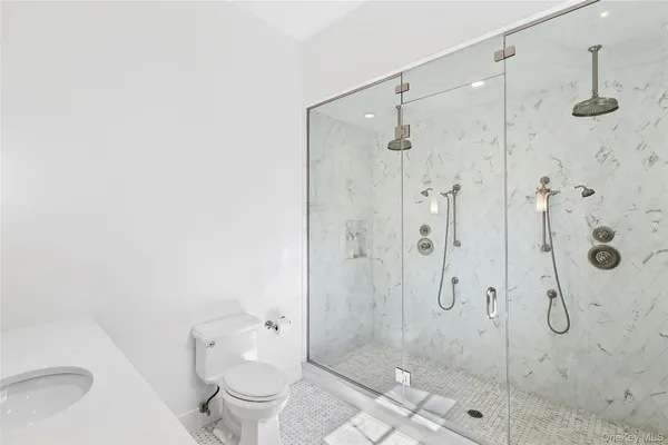 a bathroom with a granite countertop toilet a sink and shower
