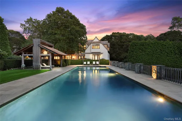 a view of a house with swimming pool next to a yard