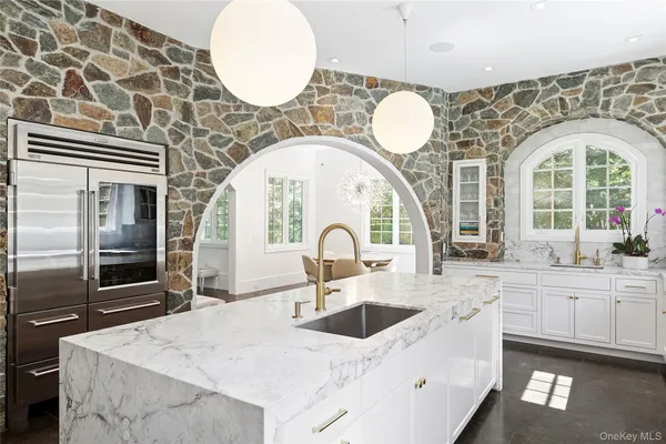 a large white kitchen with stainless steel appliances granite countertop a sink and a granite counter tops