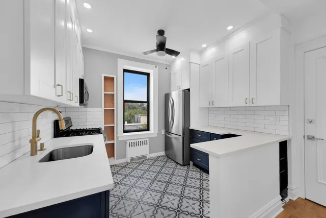 a kitchen with stainless steel appliances a sink a stove a refrigerator and cabinets