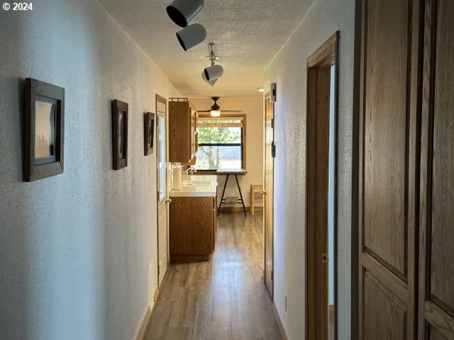 a view of a hallway with wooden floor windows and livingroom view