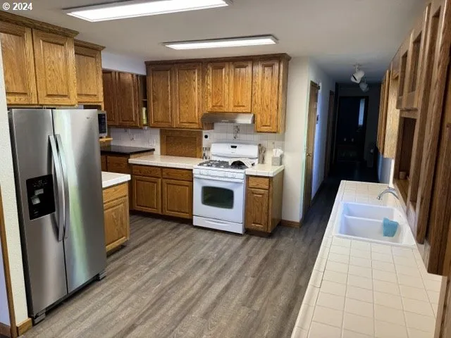 a kitchen with a stove a sink and a refrigerator