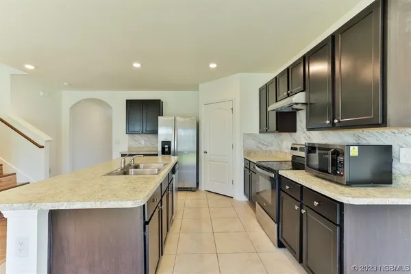 a kitchen with stainless steel appliances granite countertop a sink stove and refrigerator