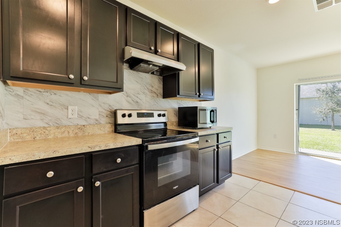 206 Old Mill Edgewater, FL 32141 - Photo 22 of 66 a kitchen with stainless steel appliances granite countertop a stove a sink and a microwave