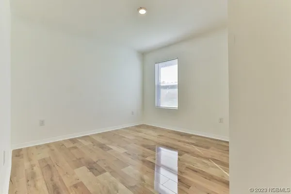 a view of a room with wooden floor and windows