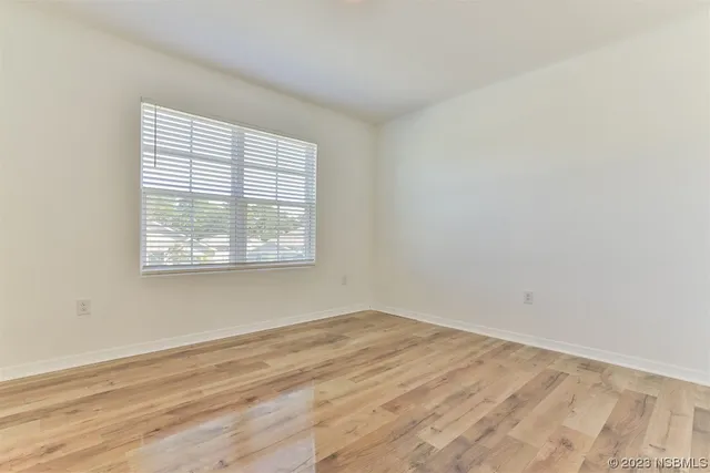 a view of a lake with a yard and trees in the background