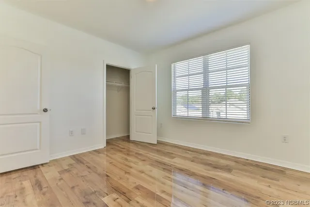 a palm tree sitting in front of a house with a big yard
