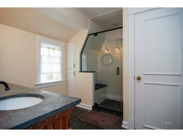 187 Ridge Avenue Winnetka, IL 60093 - Photo 9 of 18 a bathroom with a granite countertop sink a mirror and a shower