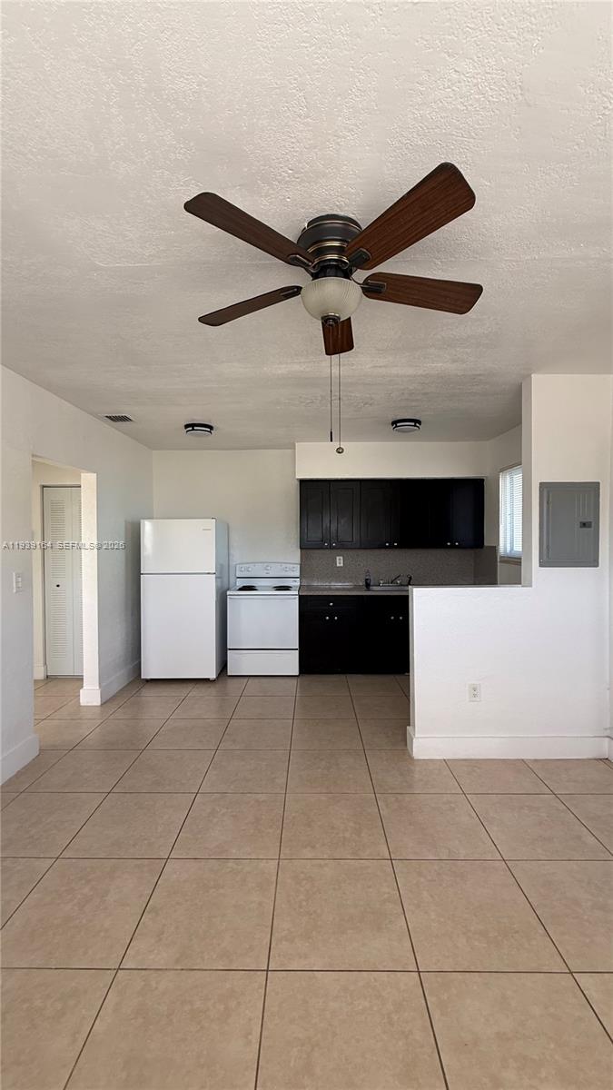 5700 Southwest 4th Street, Unit 1 Miami, FL 33144 - Photo 3 of 8 a view of a kitchen with furniture and a ceiling fan