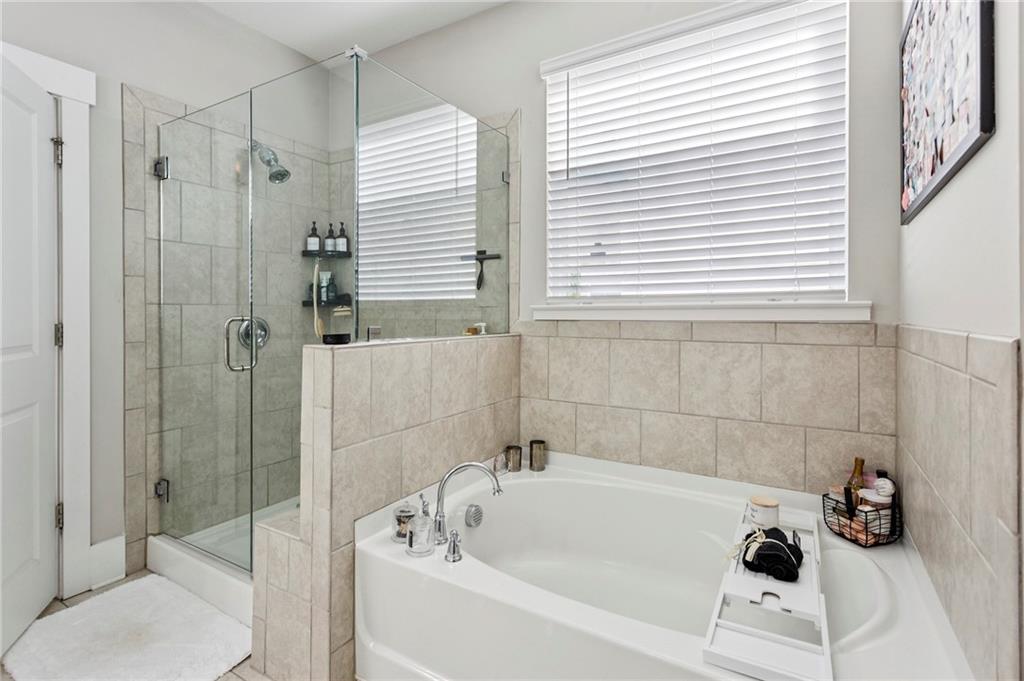 4006 Glendianne Way Powder Springs, GA 30127 - Photo 13 of 21 a white bath tub sitting next to a white sink and vanity