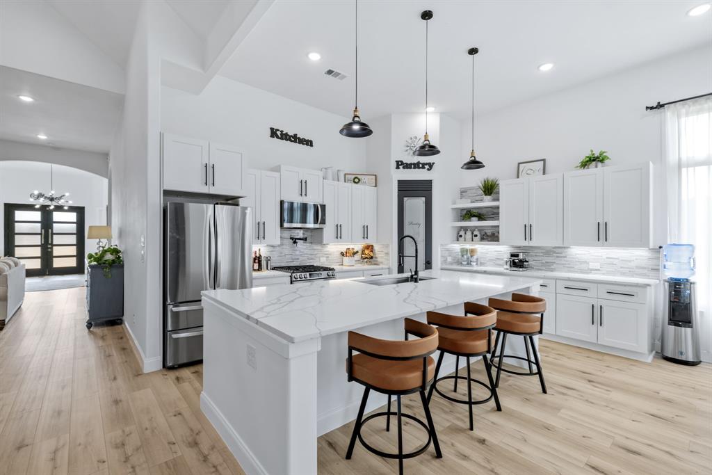 971 Sister Grove Road Van Alstyne, TX 75495 - Photo 12 of 38 a kitchen with stainless steel appliances kitchen island granite countertop a table chairs refrigerator and microwave