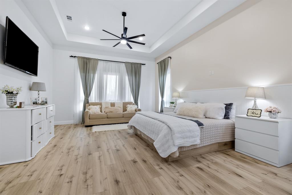 971 Sister Grove Road Van Alstyne, TX 75495 - Photo 15 of 38 a spacious bedroom with a bed and a flat screen tv