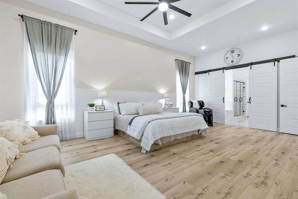 971 Sister Grove Road Van Alstyne, TX 75495 - Photo 16 of 38 a spacious bedroom with a large bed and a chandelier