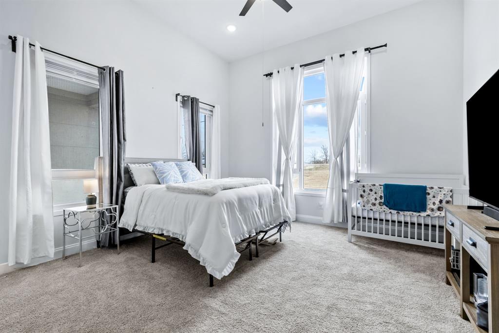971 Sister Grove Road Van Alstyne, TX 75495 - Photo 24 of 38 a spacious bedroom with a bed and a flat tv screen