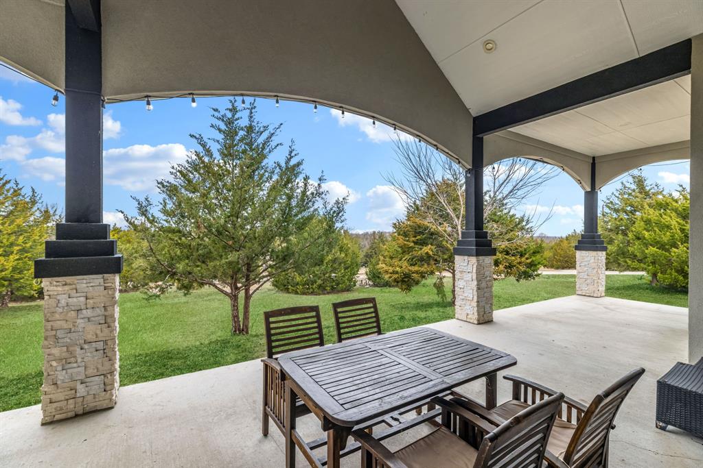 971 Sister Grove Road Van Alstyne, TX 75495 - Photo 26 of 38 a view of a patio with table and chairs potted plants with wooden floor and fence