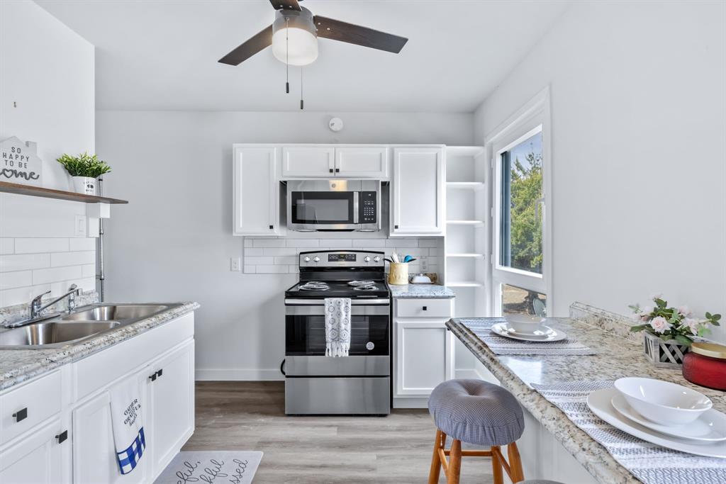 971 Sister Grove Road Van Alstyne, TX 75495 - Photo 29 of 38 a kitchen with granite countertop a sink stove and microwave