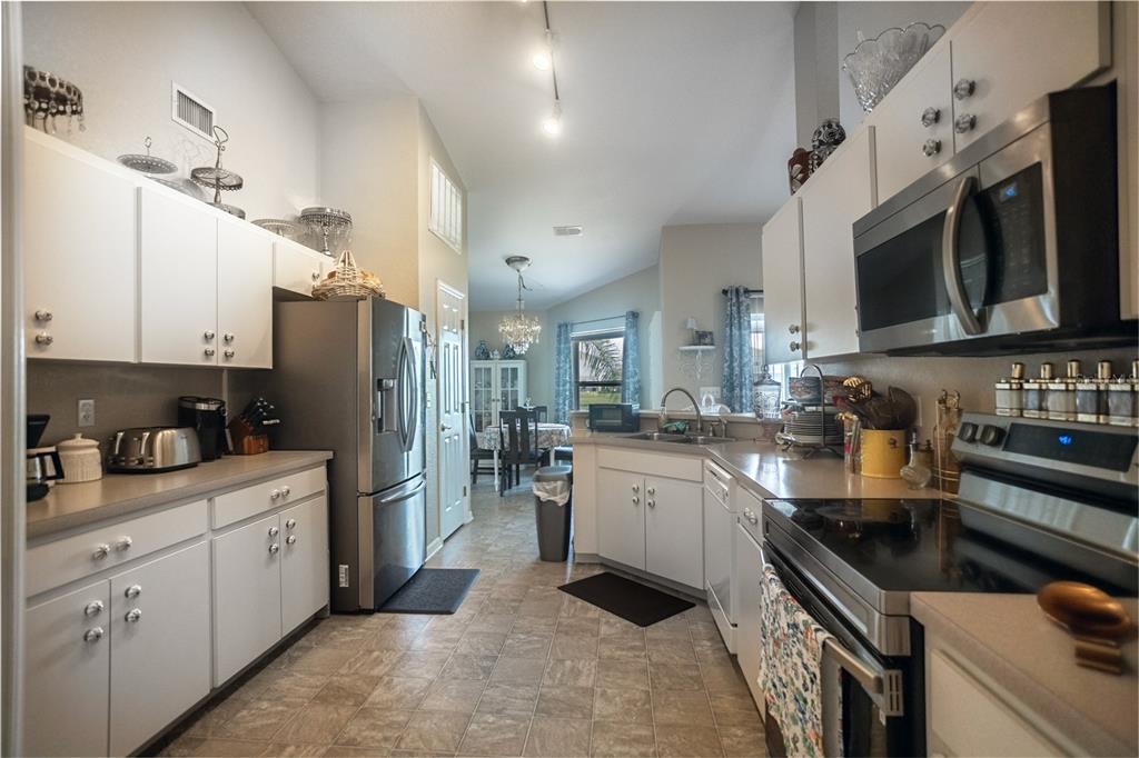 1070 Summer Glen Drive Winter Haven, FL 33880 - Photo 36 of 40 a kitchen with stainless steel appliances granite countertop a sink stove refrigerator and cabinets