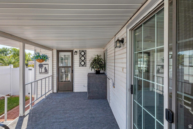 2990 East Riverside Drive, Unit 173 St. George, UT 84790 - Photo 27 of 38 Covered porch with outdoor carpeting and white vinyl siding