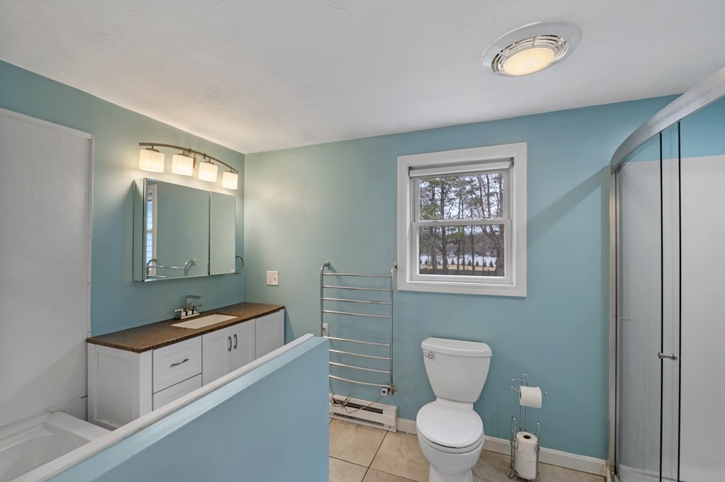 26 Temple Drive Methuen, MA 01844 - Photo 27 of 38 a bathroom with a toilet a sink a mirror and a window