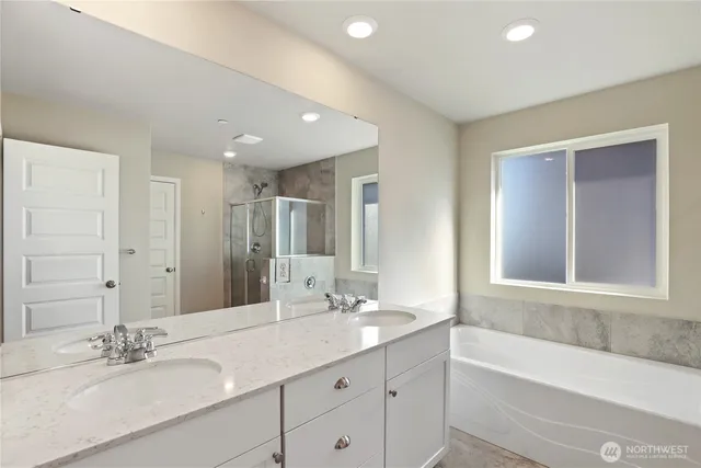 a bathroom with a double vanity sink bathtub double and mirror