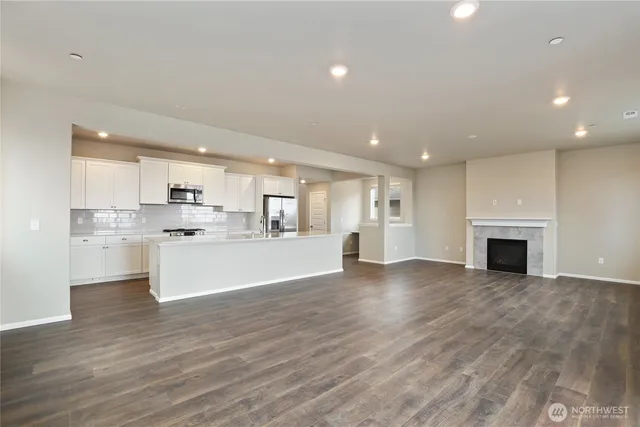 a view of kitchen with granite countertop stove top oven and cabinets