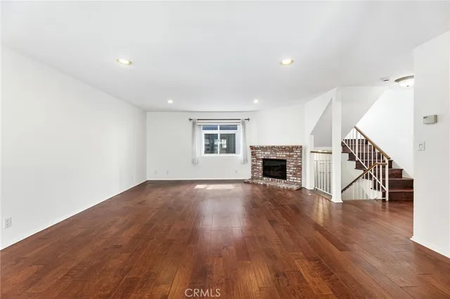 a view of empty room with wooden floor and fireplace