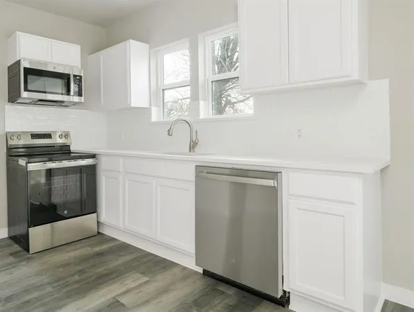a kitchen with white cabinets and a stove top oven
