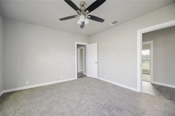 an empty room with a ceiling fan and a window