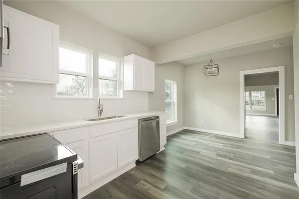a view of a kitchen with wooden floor and a window