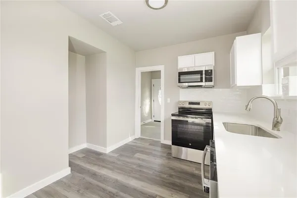 a kitchen with granite countertop a refrigerator stove and sink