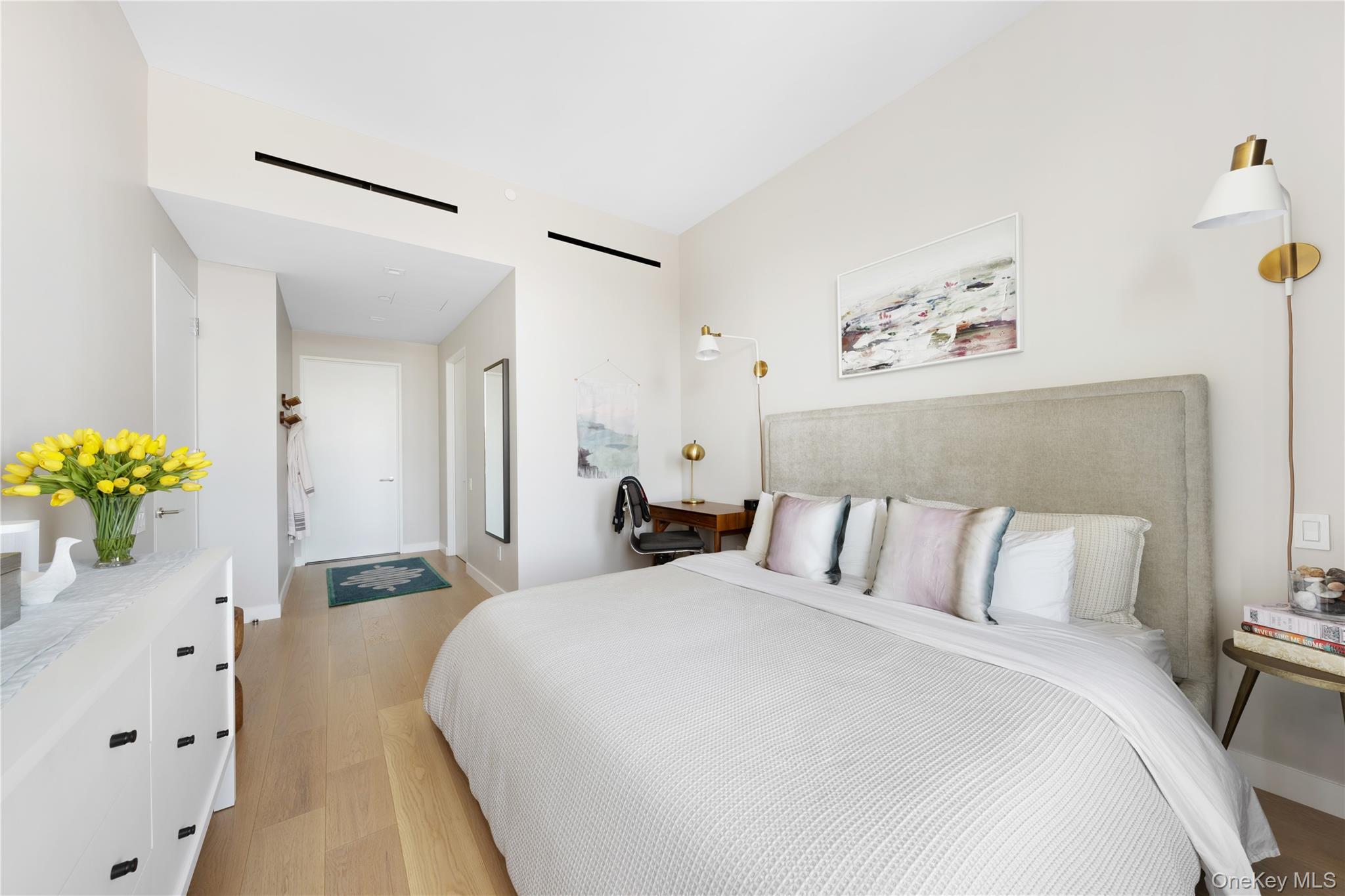 21-21 31st Street, Unit 4E Queens, NY 11105 - Photo 12 of 25 a bedroom with a bed and a chandelier