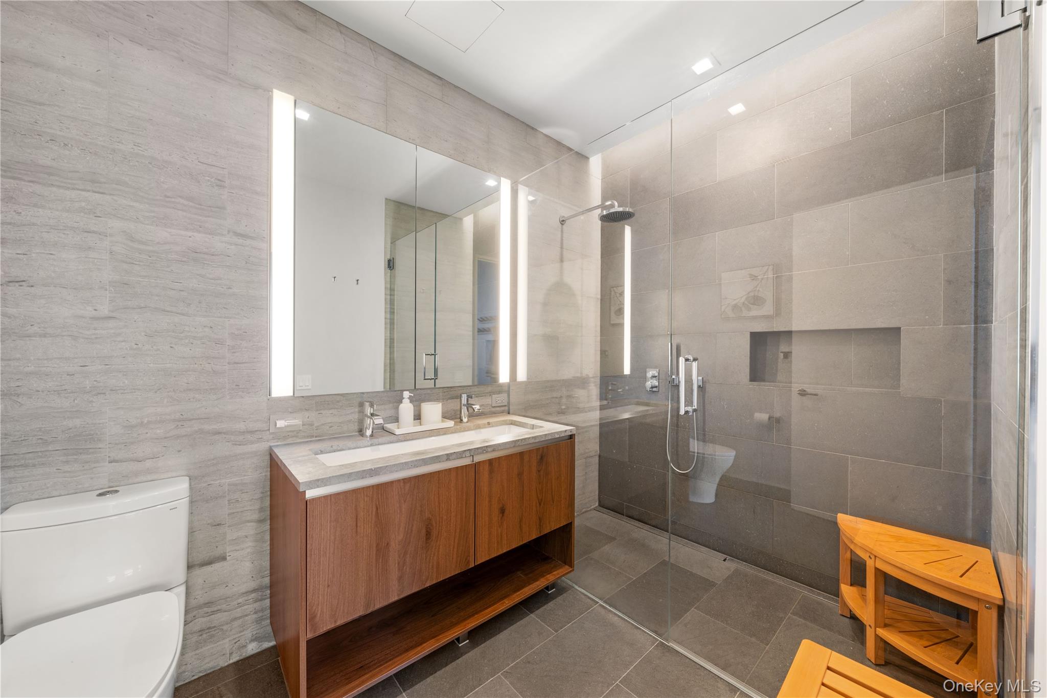 21-21 31st Street, Unit 4E Queens, NY 11105 - Photo 15 of 25 a bathroom with a double vanity sink toilet mirror and bathtub
