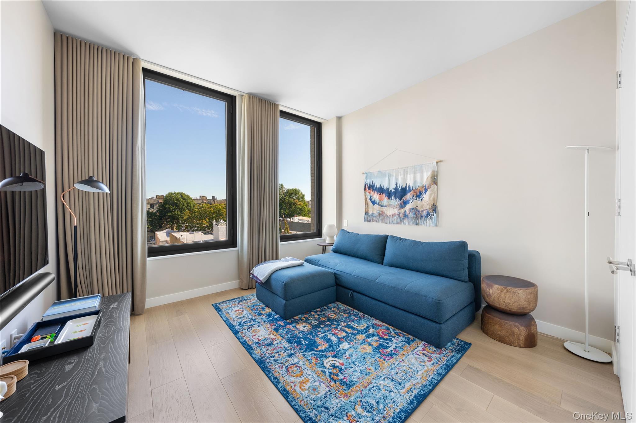 21-21 31st Street, Unit 4E Queens, NY 11105 - Photo 17 of 25 a living room with furniture and a window