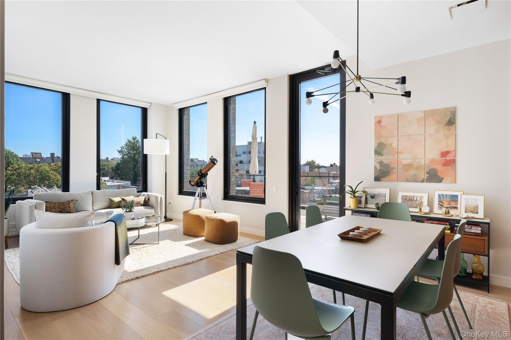 21-21 31st Street, Unit 4E Queens, NY 11105 - Photo 2 of 25 a view of a dining room with furniture large windows and wooden floor