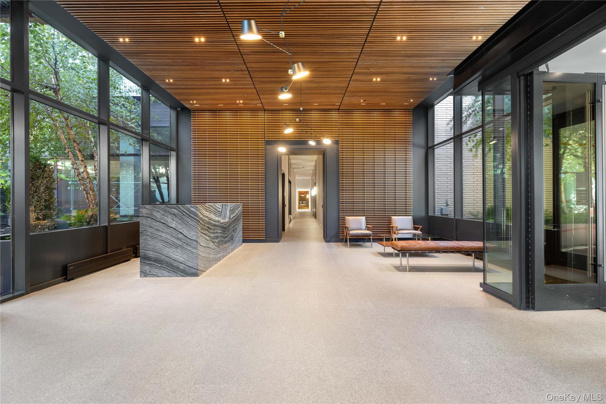 21-21 31st Street, Unit 4E Queens, NY 11105 - Photo 24 of 25 a view of a lobby with furniture and floor to ceiling window