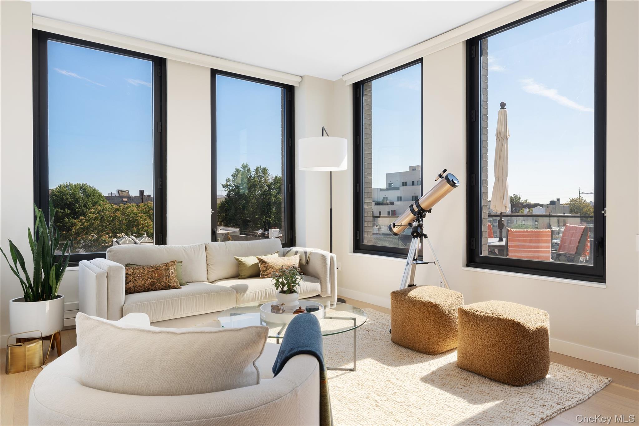21-21 31st Street, Unit 4E Queens, NY 11105 - Photo 3 of 25 a living room with furniture and a large window