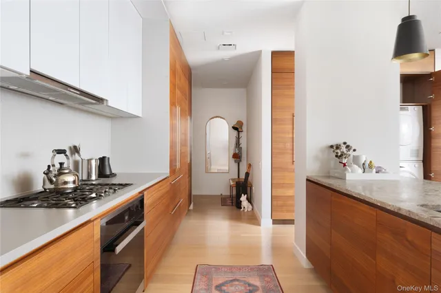 a kitchen with stainless steel appliances granite countertop a table chairs in it and white cabinets