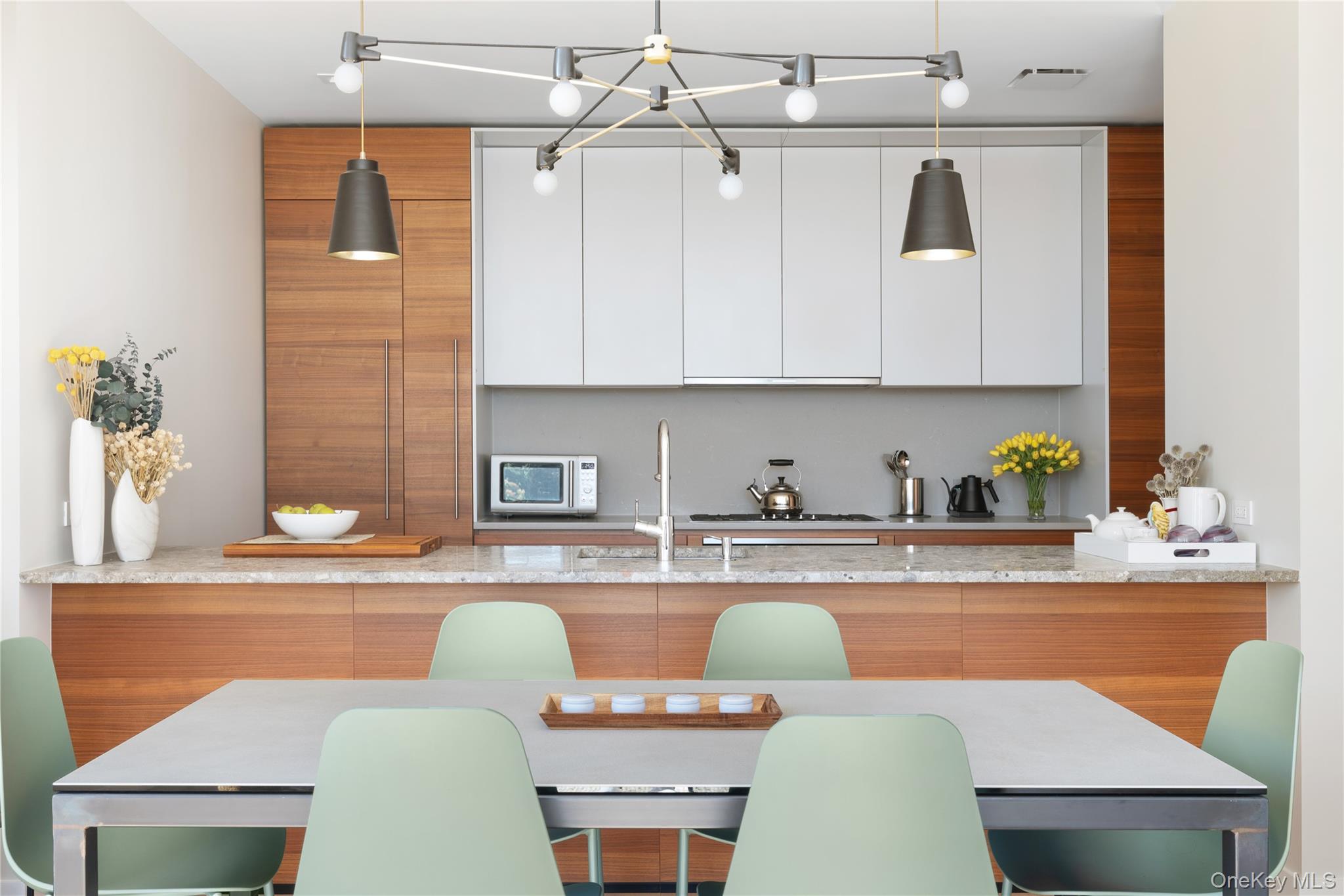 21-21 31st Street, Unit 4E Queens, NY 11105 - Photo 10 of 25 a kitchen with stainless steel appliances granite countertop a table chairs in it and white cabinets