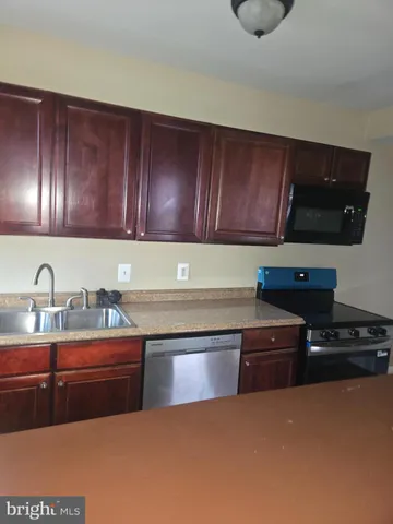 a kitchen with granite countertop a sink and a stove top oven