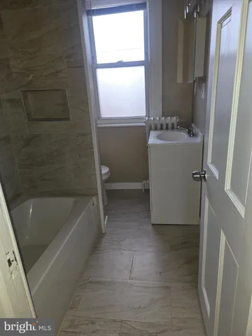 a bathroom with a sink a bathtub and window
