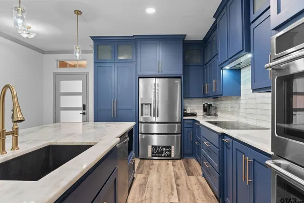 a kitchen with stainless steel appliances wooden cabinets a sink and a stove